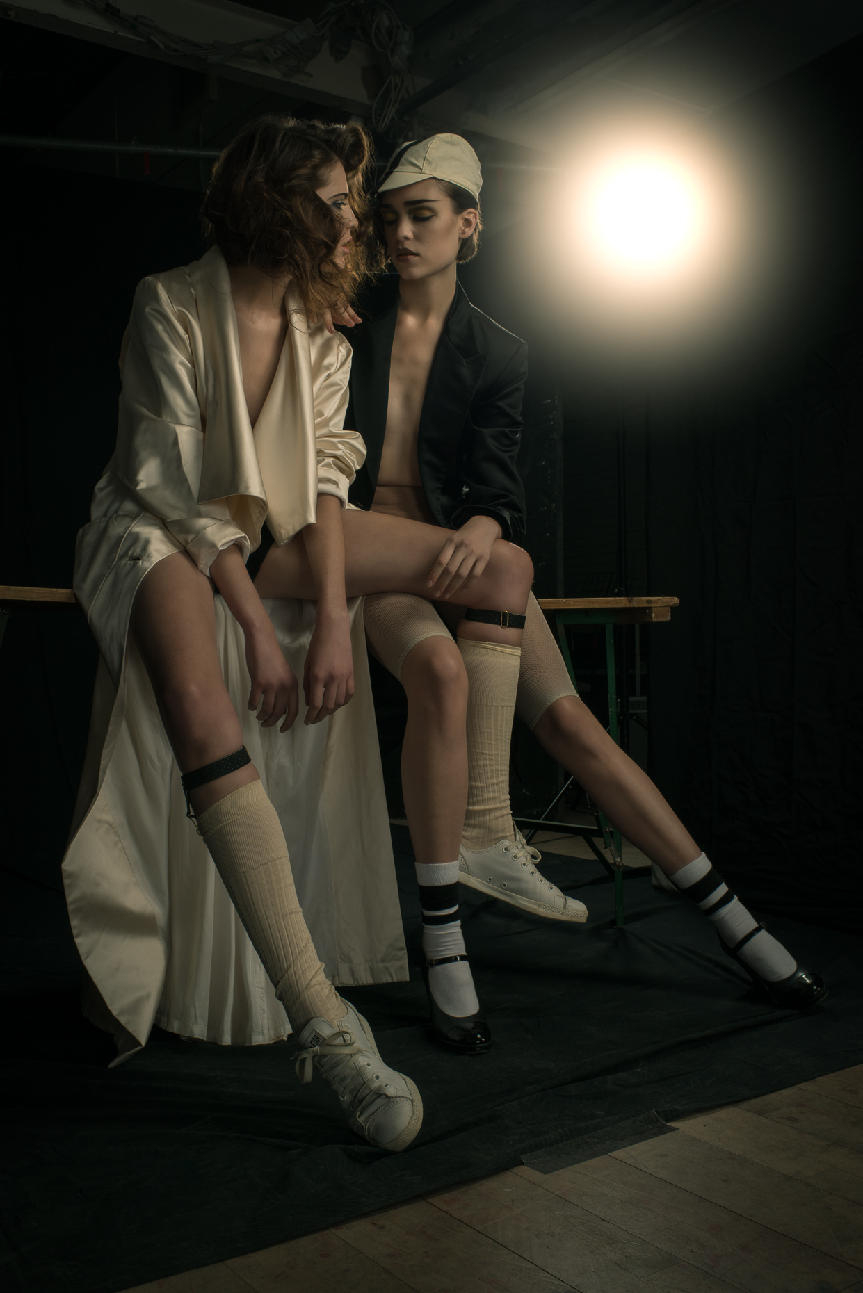2 fashion models sitting together photograph by marc rogoff