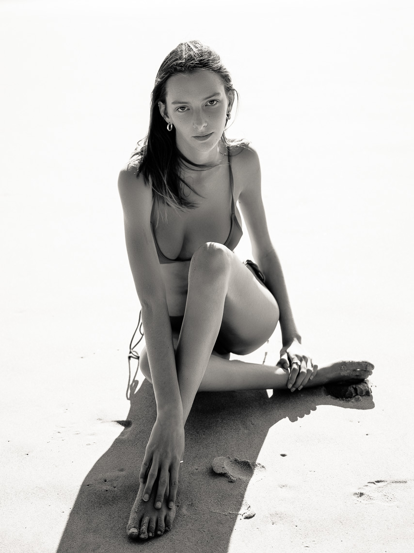 fashion model in bikini sitting on sand photograph by marc rogoff